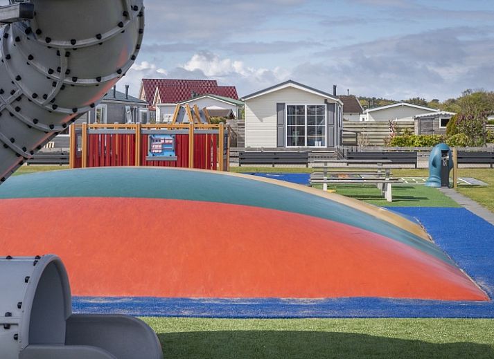 Cozy living room in Chalet Bregkoog 227, Chaletpark Bregkoog, De Koog, Texel with comfortable sofa and colorful armchair.