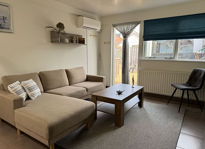 Cozy living room of Duo bungalow in De Koog, Texel with comfortable seating area and lots of natural light.