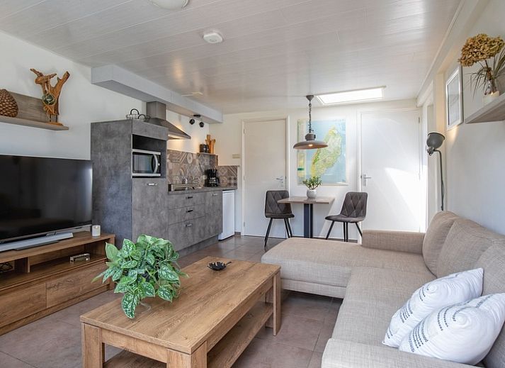 Cozy living room of Duo bungalow in De Koog, Texel with comfortable seating area and lots of natural light.