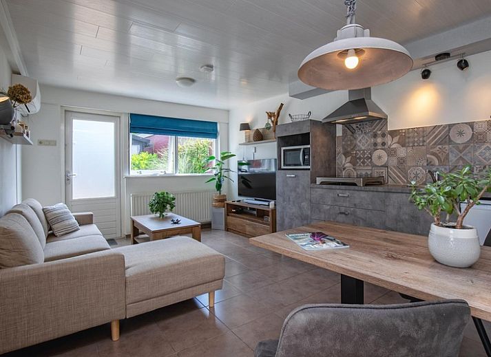 Cozy living room of Duo bungalow in De Koog, Texel with comfortable seating area and lots of natural light.