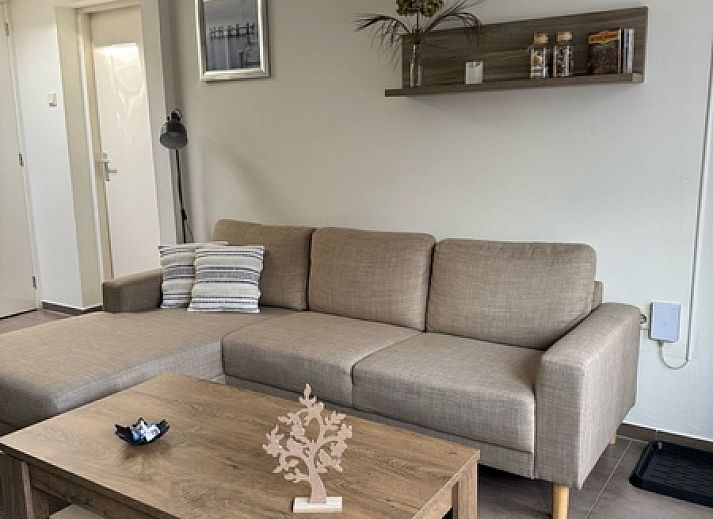 Cozy living room of Duo bungalow in De Koog, Texel with comfortable seating area and lots of natural light.
