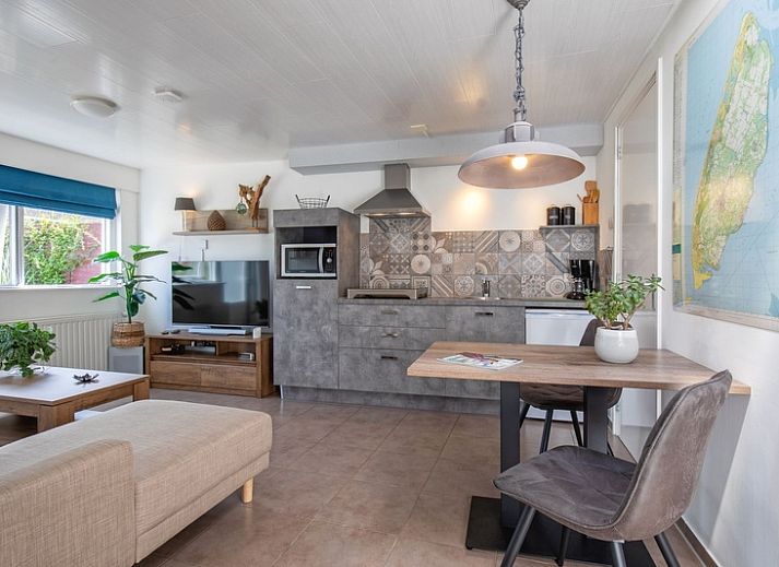 Cozy living room of Duo bungalow in De Koog, Texel with comfortable seating area and lots of natural light.