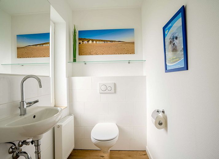 Cozy interior of Orchismient 14 vacation home in De Koog Texel with modern decor and art on the wall.