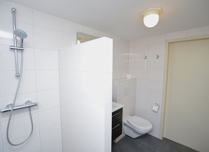 Cozy living room in Holiday home Stappeland 213, De Koog, Texel with comfortable seating area and garden view.