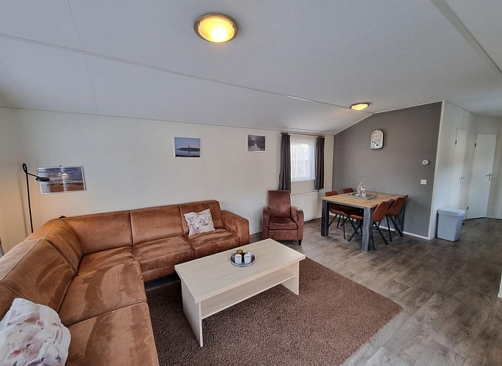 Cozy living room in Chaletpark Bregkoog - Chalet Bregkoog 235, De Koog, Texel with comfortable sitting area and dining area.