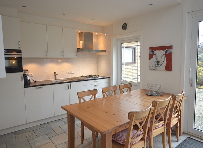 Cozy living room of vacation home Epelaan 31 in De Koog, Texel with modern furnishings and garden views.