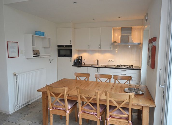 Cozy living room of vacation home Epelaan 31 in De Koog, Texel with modern furnishings and garden views.
