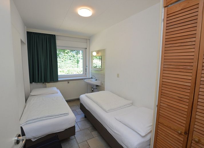 Cozy living room of vacation home Epelaan 31 in De Koog, Texel with modern furnishings and garden views.