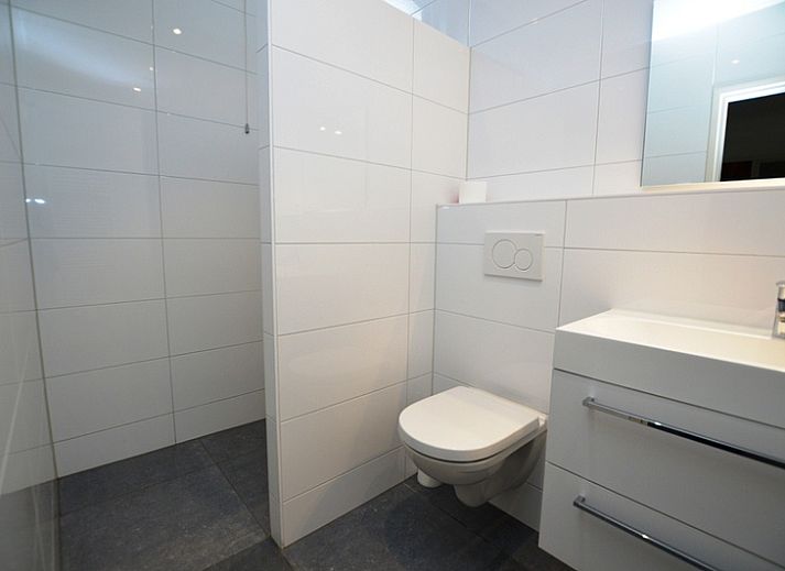 Cozy living room of vacation home Epelaan 31 in De Koog, Texel with modern furnishings and garden views.