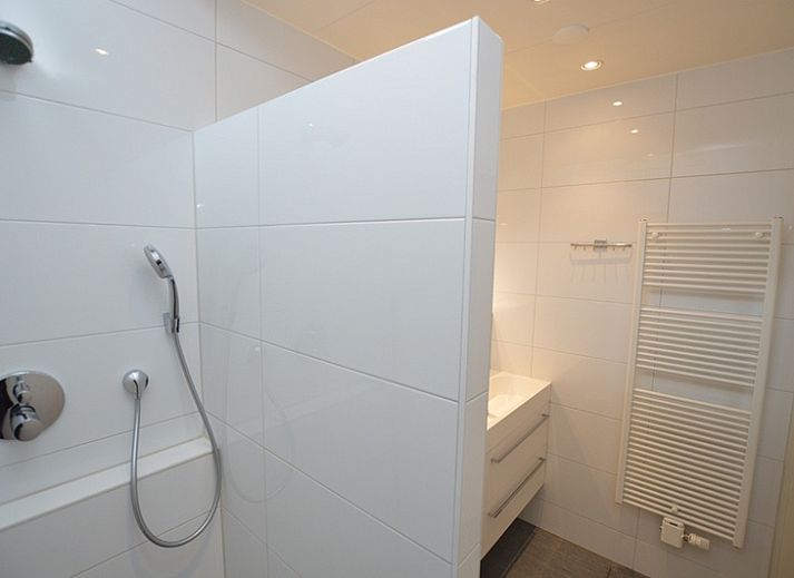 Cozy living room of vacation home Epelaan 31 in De Koog, Texel with modern furnishings and garden views.