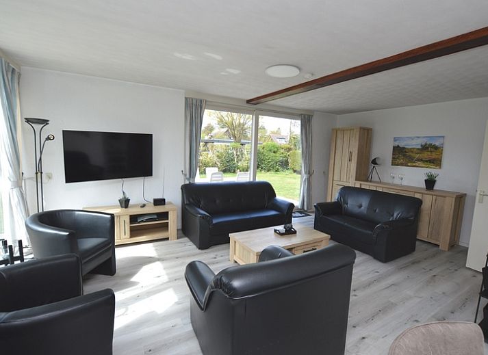 Ruime woonkamer in Orchismient 33 vakantiehuis De Koog Texel met uitzicht op tuin.