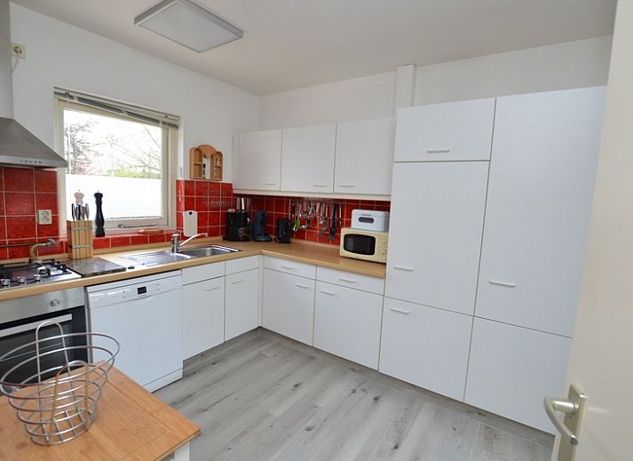 Ruime woonkamer in Orchismient 33 vakantiehuis De Koog Texel met uitzicht op tuin.