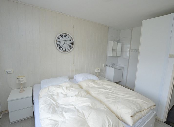 Ruime woonkamer in Orchismient 33 vakantiehuis De Koog Texel met uitzicht op tuin.