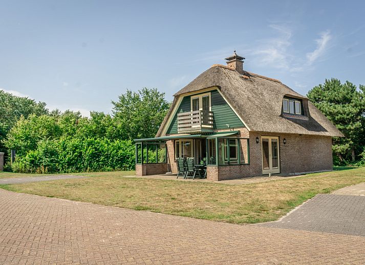 Villa in De Koog, Texel, met rieten dak en ruime veranda voor een ontspannen verblijf op de Waddeneilanden.