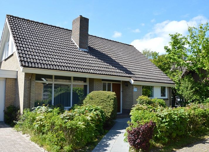 Charming vacation home Orchismient 27 in De Koog, Texel, with green garden and inviting facade.