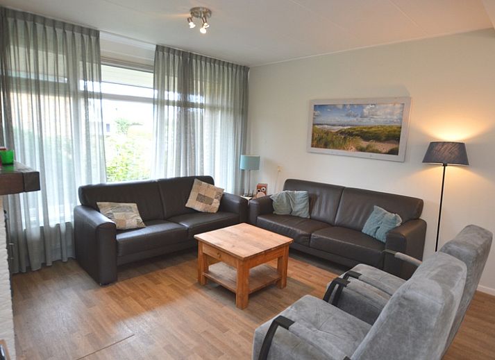 Charming vacation home Orchismient 27 in De Koog, Texel, with green garden and inviting facade.