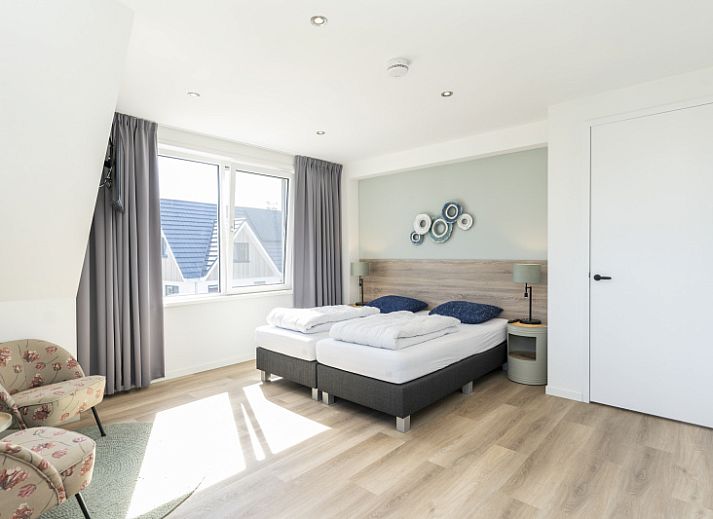 Bright living room in Villa 37a, De Koog, Texel, vacation home with comfortable seating area and views of nature.