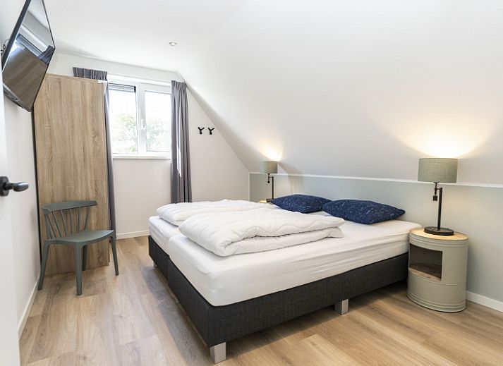 Bright living room in Villa 37a, De Koog, Texel, vacation home with comfortable seating area and views of nature.