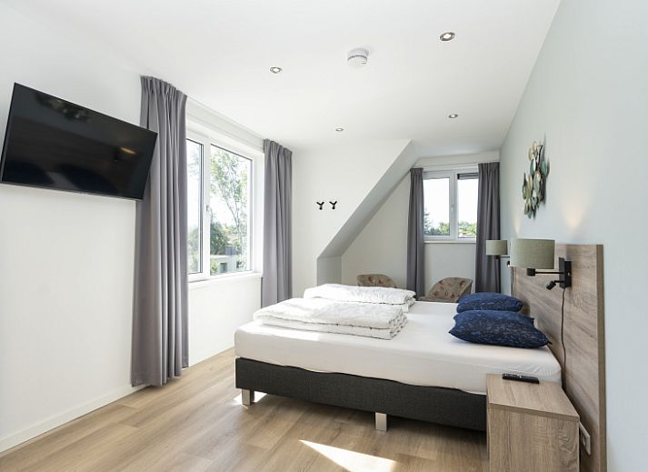 Bright living room in Villa 37a, De Koog, Texel, vacation home with comfortable seating area and views of nature.