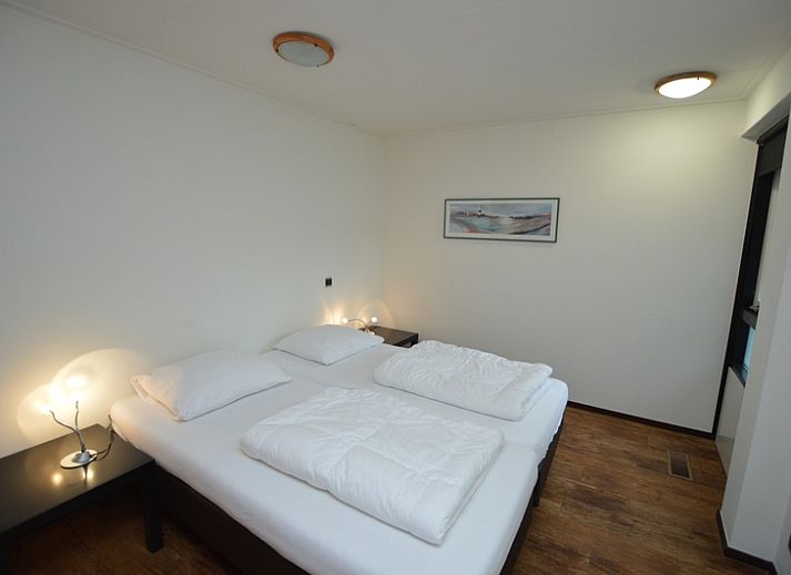 Cozy living room of Orchismient 28 De Koog Texel with fireplace and sitting area.