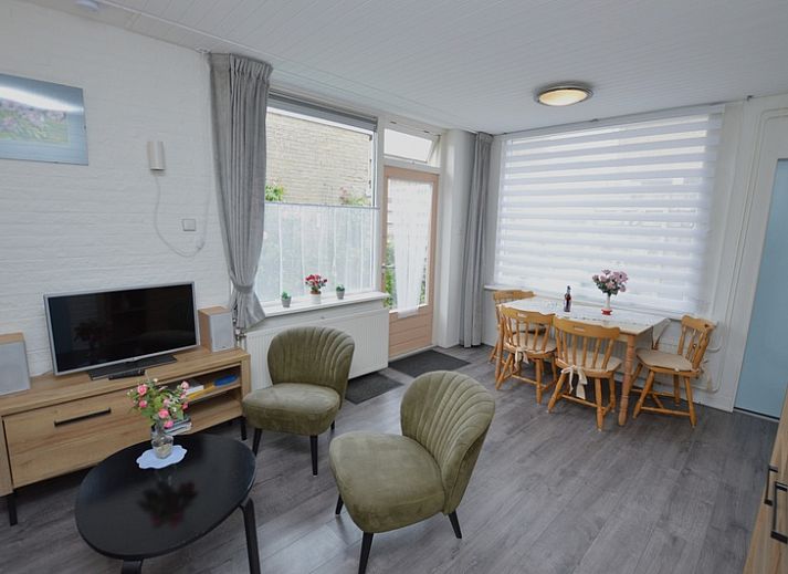 Cozy terrace at Plevierstraat 18 vacation home in De Koog, Texel with outdoor seating and flowering garden.