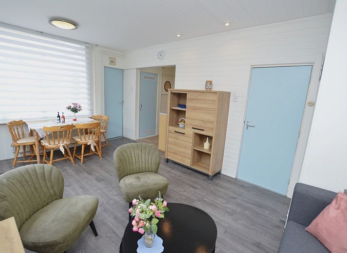 Cozy terrace at Plevierstraat 18 vacation home in De Koog, Texel with outdoor seating and flowering garden.