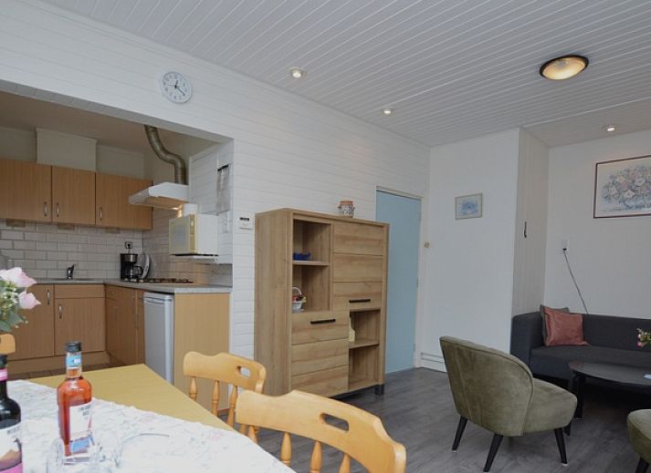 Modern living room in vacation home Plevierstraat 18, De Koog, Texel with comfortable seating area and wooden cupboard.