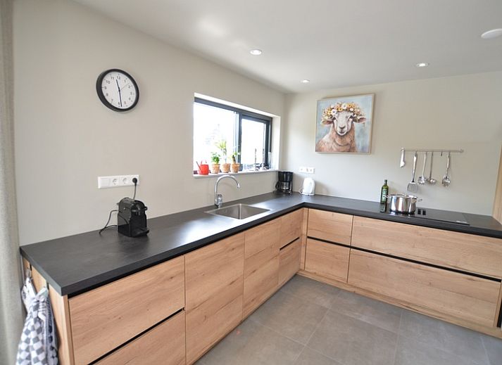 Gemuetliches Wohnzimmer in der Ruijslaan 73, De Koog, Texel, mit bequemen Sofas und grossen Fenstern.