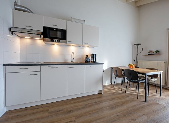 Gezellige woonkamer Motel Texel Appartement (Z) in De Koog, Texel met veel lichtinval en comfortabele zitplekken.