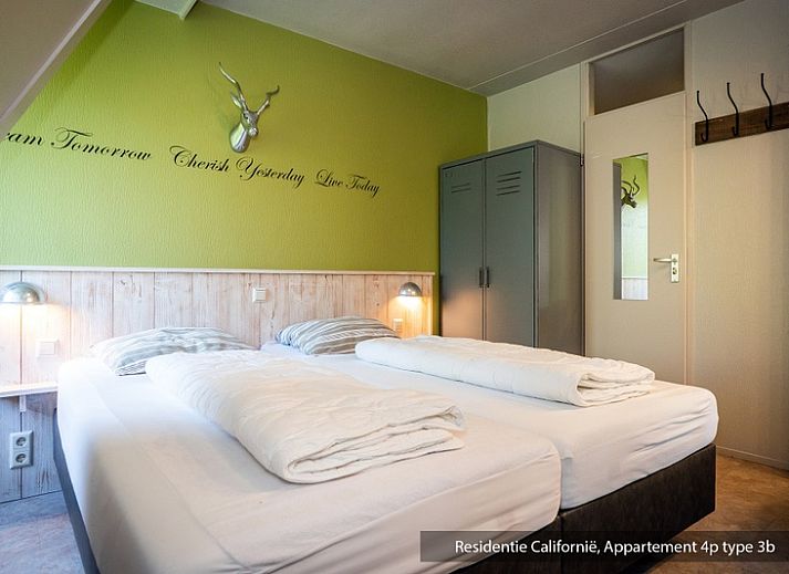 Modern open kitchen and dining area in Type 3B vacation home, De Koog, Texel, with stylish furnishings and blue accents.