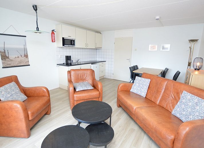 Gemuetliche Sitzecke im Motel Texel - Apartment 208/1L, De Koog, Texel, mit bequemen Ledersofas und einer offenen Kueche.
