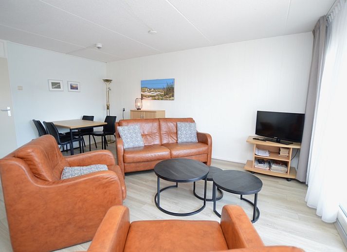 Gemuetliche Sitzecke im Motel Texel - Apartment 208/1L, De Koog, Texel, mit bequemen Ledersofas und einer offenen Kueche.