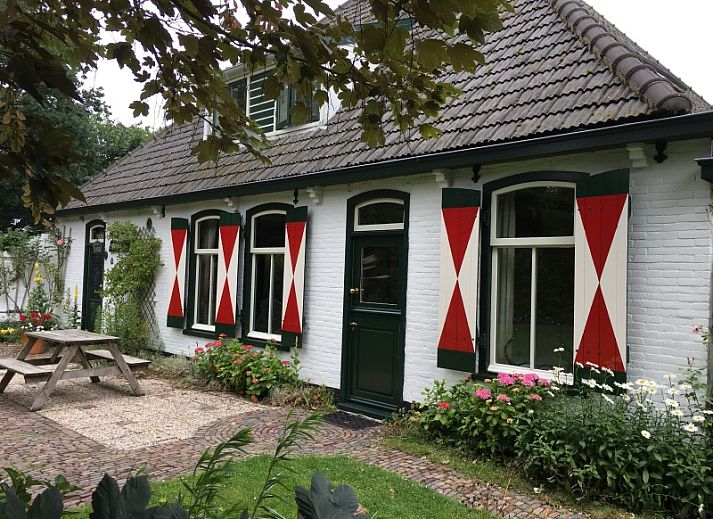 Front house vacation home in De Koog Texel with traditional facade and green shutters.
