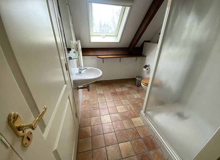 Cozy terrace at Voorhuis vacation home in De Koog Texel surrounded by greenery.