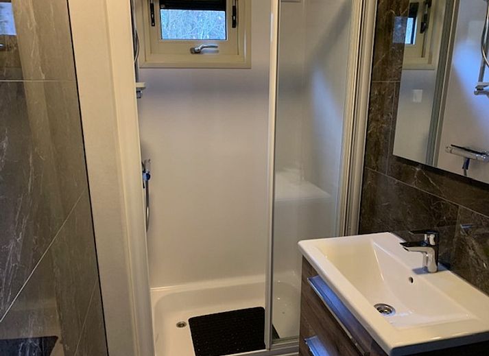 Vacation home Chalet Bregkoog 203, located in De Koog, Texel, with spacious driveway and green surroundings.