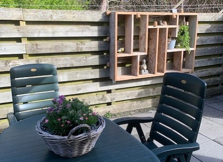 Terrace Chalet Bregkoog 203 on Texel, De Koog with cozy seating area and green plants.