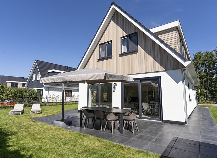 Villa 19 in De Koog, Texel, bietet eine geraeumige Terrasse mit modernen Sitzgelegenheiten, ideal fuer Sommerabende auf den Watteninseln.