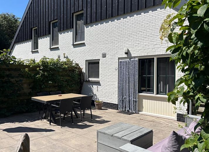 Enjoy the sunny patio at Cottage in De Koog, Texel, with comfortable outdoor furniture and green surroundings.