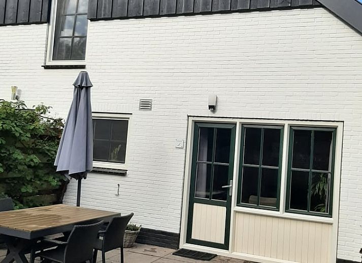Enjoy the sunny patio at Cottage in De Koog, Texel, with comfortable outdoor furniture and green surroundings.