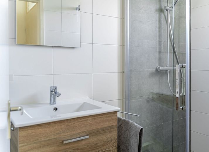 Exterior of vacation home De Anemoon in De Koog, Texel, surrounded by colorful flowers.