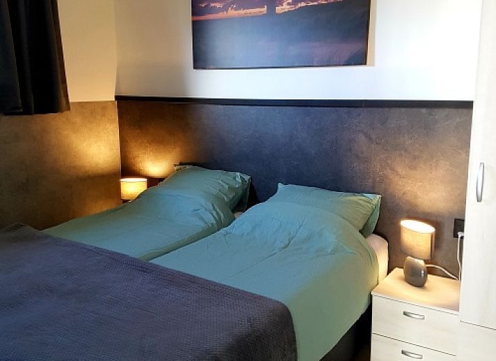 Exterior of vacation home De Anemoon in De Koog, Texel, surrounded by colorful flowers.