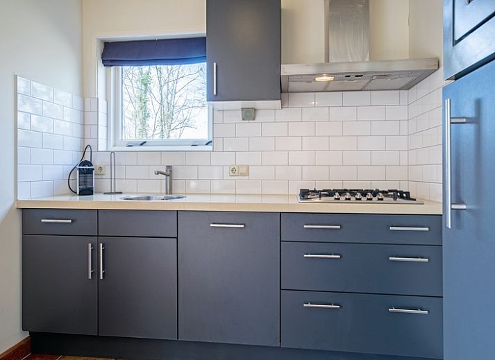 Veranda des Ferienhauses De Zonneweelde in De Koog, Texel, mit gruener Umgebung und Sitzgelegenheiten.