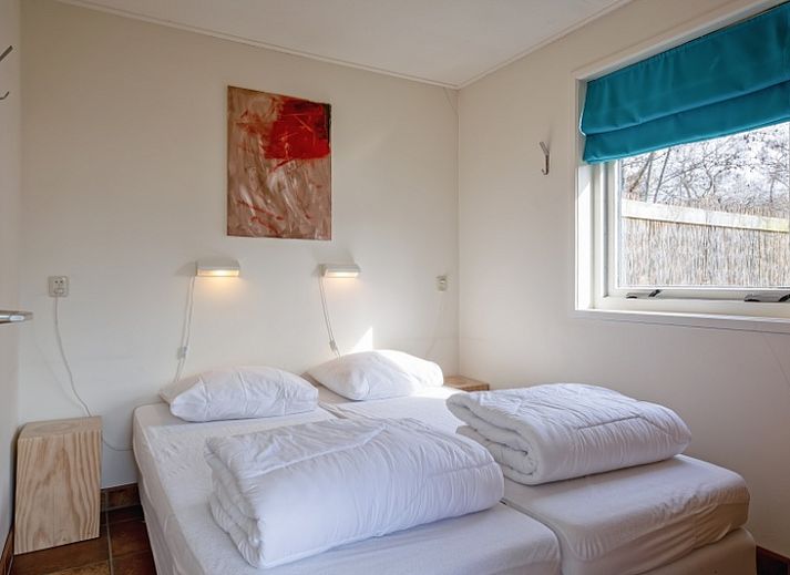 Terrasse von De Zonneweelde in De Koog, Texel, mit Blick auf den Garten und bequemen Stuehlen.