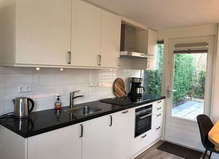 't Buitenhuisje in De Koog Texel, cozy living room of vacation home with modern furnishings and comfortable chairs.