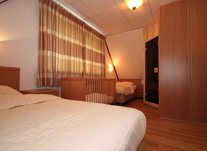 Cozy living room in 6 Person luxury villa with sauna, De Koog, Texel. Comfortable sitting area with fireplace and modern amenities.