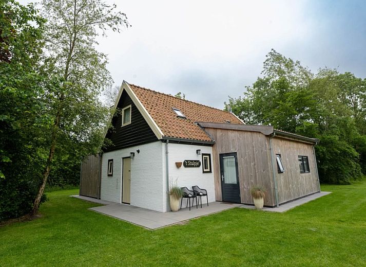 Eetruimte van Landgoed Springtij Stulpje, vakantiehuis in De Koog, Texel, met houten tafel en stijlvolle keuken.