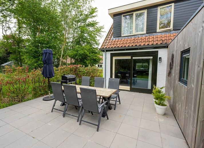 Eetruimte van Landgoed Springtij Stulpje, vakantiehuis in De Koog, Texel, met houten tafel en stijlvolle keuken.