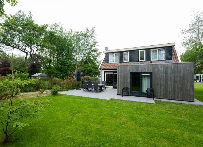 Eetruimte van Landgoed Springtij Stulpje, vakantiehuis in De Koog, Texel, met houten tafel en stijlvolle keuken.
