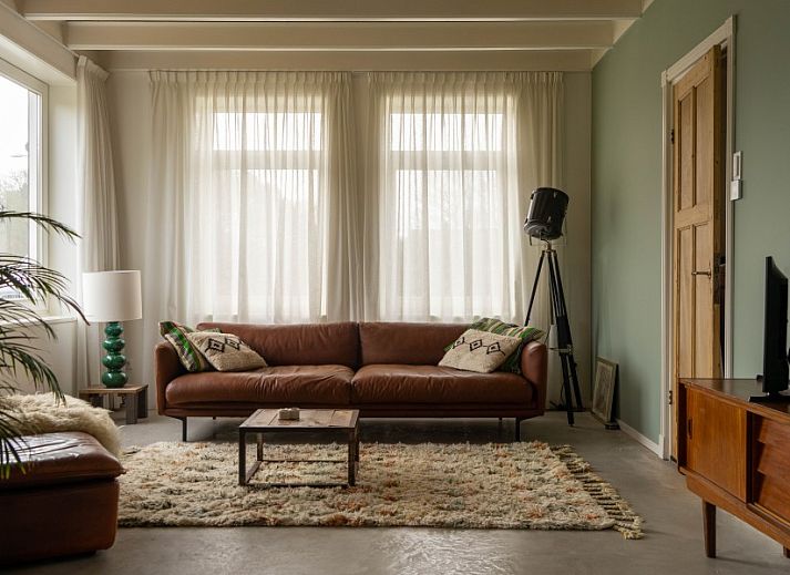 Gezellige zithoek met haard in Paal 234, een vakantiehuis in De Koog, Texel.