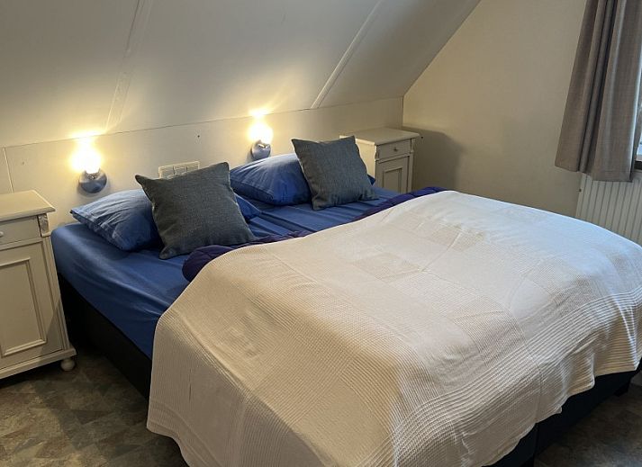 Cozy living room of Koetshuis vacation home in De Koog, Texel, with comfortable sofas and a television for relaxation.